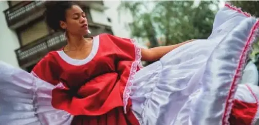 Mujer bailando marimba con vestimenta tradicional.