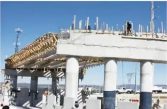 Construcción de una autopista con pilares de concreto y maquinaria.