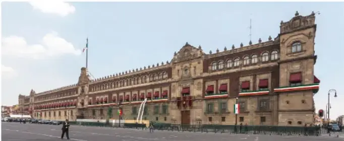 Fotografía de un edificio gubernamental de estilo neoclásico con banderas de México, probablemente una sede del Poder Ejecutivo o Legislativo.