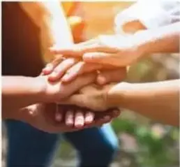 Manos juntas en señal de trabajo en equipo.
