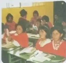 Foto de niños indígenas en aula con maestra.