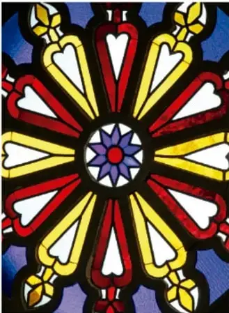 Rosetón o vitral con figuras geométricas de colores que forman un patrón radial.
