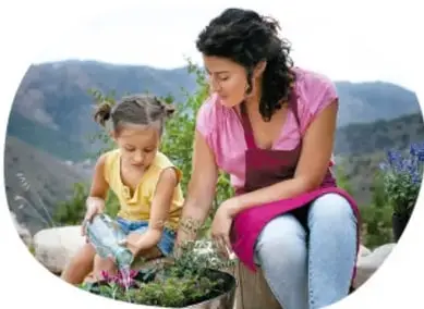 Madre e hija regando plantas con una regadera en un entorno natural, ilustrando la reutilización del agua.