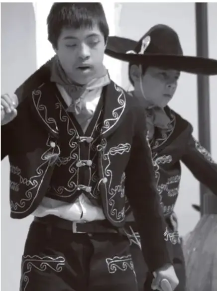 Fotografía en blanco y negro de dos niños con traje tradicional mexicano (charrería) con sombrero, participando en una actividad cultural.