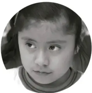 Fotografía en blanco y negro de una niña con expresión pensativa, dentro de un círculo.