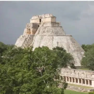 Pirámide escalonada de piedra rodeada de vegetación, probablemente una zona arqueológica maya.