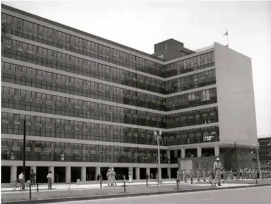Fotografía en blanco y negro de un edificio moderno de varios pisos, probablemente una dependencia gubernamental relacionada con el trabajo o la previsión social.