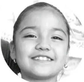 Fotografía en blanco y negro del rostro sonriente de una niña, con un fondo tenue de lo que parece ser un mapa o dibujo.