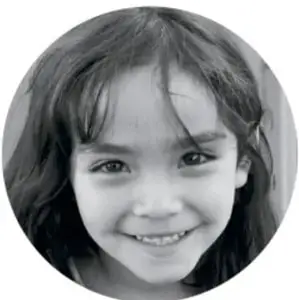 Retrato circular en blanco y negro de una niña sonriente de cabello largo, probablemente la estudiante que realiza las actividades.