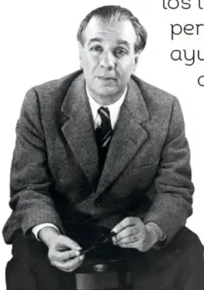 Fotografía en blanco y negro del escritor Jorge Luis Borges sentado, con saco y corbata, sosteniendo algo entre las manos.