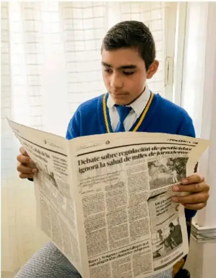 Fotografía de un estudiante leyendo un periódico con titular sobre debate sobre regulación de pesticidas, crédito Luis Eduardo García Medel, TLAXCALA.