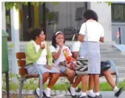 Fotografía de un grupo de estudiantes conversando y conviviendo en un espacio escolar al aire libre.