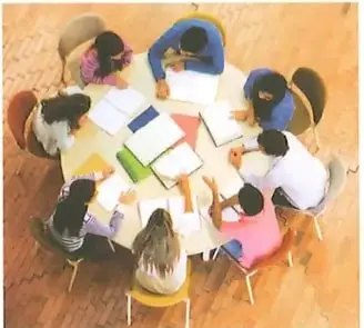 Grupo de estudiantes reunidos alrededor de una mesa para realizar un trabajo colaborativo.