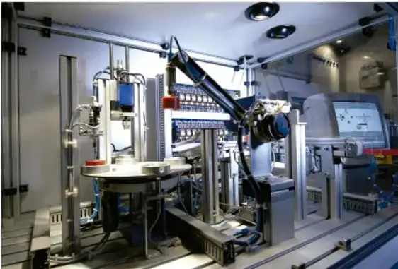 Fotografía de una máquina o sistema técnico industrial automatizado dentro de una planta, con componentes metálicos, tuberías y paneles de control, ilustrando una interacción máquina-producto.