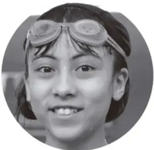Fotografía de una niña con goggles de natación sobre la frente, sonriendo.
