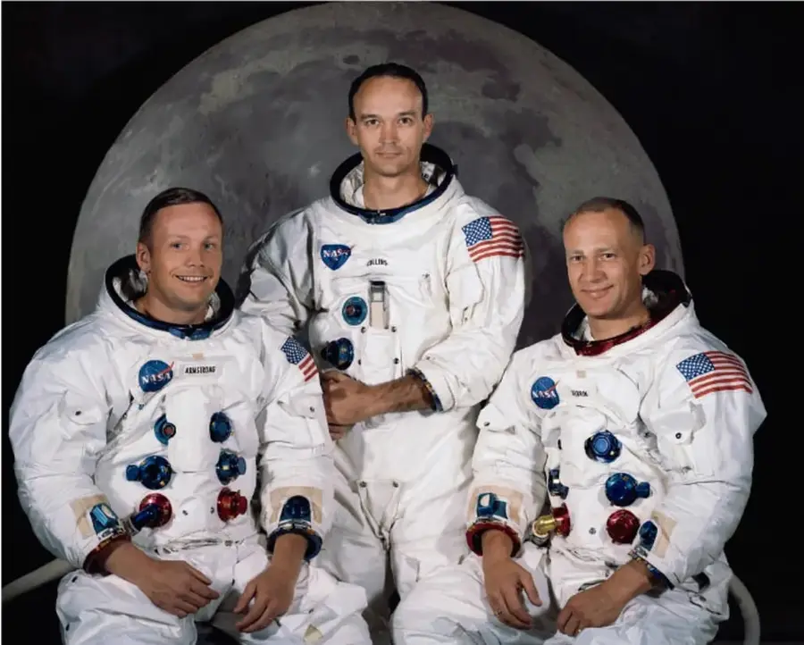 Retrato de los tres astronautas del Apolo 11 con trajes espaciales, con la Luna de fondo.