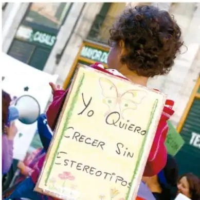 Fotografía de una niña en una marcha con un cartel que dice "Yo quiero crecer sin estereotipos".