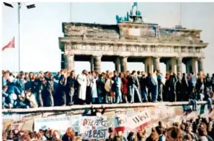 Fotografía de la Puerta de Brandeburgo con personas celebrando la caída del Muro de Berlín.