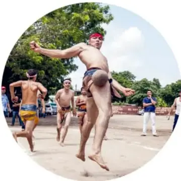 Fotografía de varios hombres jugando Ulama al aire libre, uno de ellos golpeando la bola con la cadera, en la modalidad de cadera.
