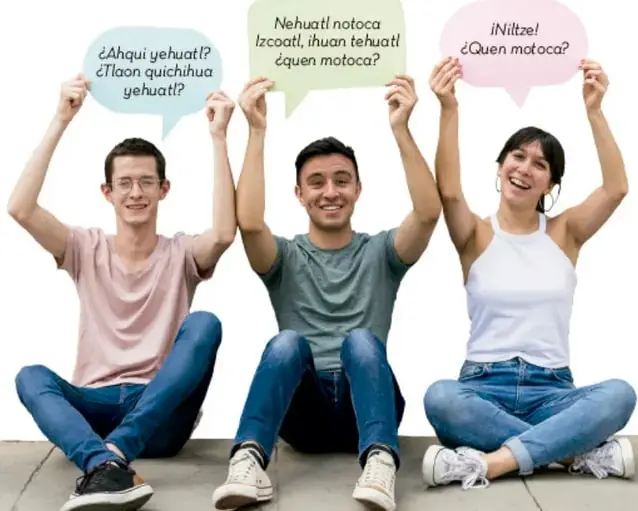 Fotografía de tres jóvenes sentados en el piso sosteniendo globos de diálogo con frases en lenguas indígenas (náhuatl): «¿Ahqui yehuatl? ¿Tlaon quichihua yehuatl?», «Nehuatl notoca Izcoatl, ihuan tehuatl ¿Quen motoca?» y «¡Niltze! ¿Quen motoca?»
