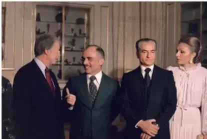 Fotografía de una reunión diplomática en la que aparecen varios hombres con traje y una mujer; uno de ellos es identificable como Reza Pahlevi.