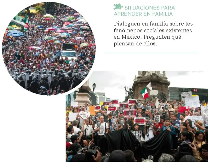 Vista aérea de una multitud en una manifestación con sombrillas de colores, junto a agentes antidisturbios con escudos, en una avenida urbana.