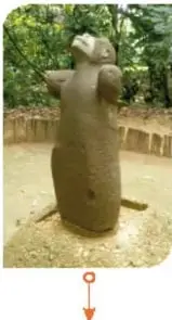 Escultura de un mono mirando hacia arriba.