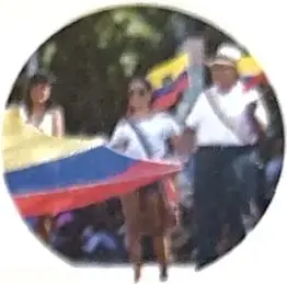 Personas sosteniendo la bandera del Ecuador, relacionada con la diversidad del país.