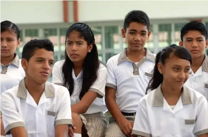 Fotografía de seis estudiantes de secundaria con uniforme blanco, sentados y mirando hacia adelante, ilustrando la asamblea de grupo.