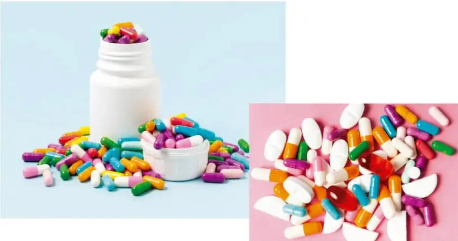 Frasco blanco de pastillas con cápsulas de colores dispersas sobre fondo azul claro.