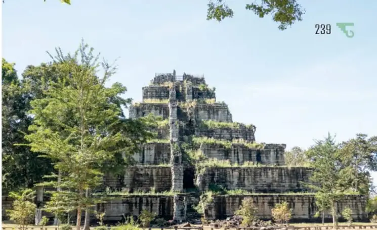 Fotografía de la pirámide escalonada de Koh Ker, de piedra cubierta en parte por vegetación, entre árboles de la selva camboyana.