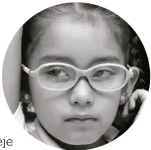 Fotografía en blanco y negro de una niña con lentes mirando de frente.