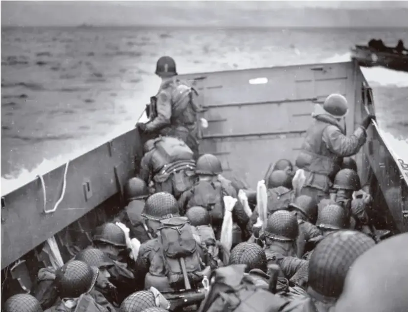 Fotografía en blanco y negro de soldados estadounidenses en una lancha de desembarco durante la Segunda Guerra Mundial.