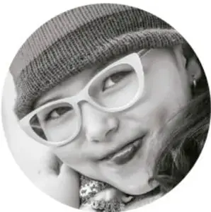 Fotografía circular de una niña con lentes y gorro de tejido, sonriendo.