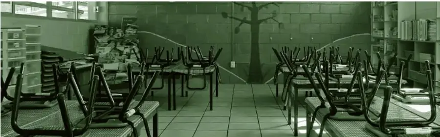 Fotografía de un aula de preescolar reorganizada: sillas apiladas y apartadas hacia los lados, mesas al fondo, mobiliario y cajas de material ordenados en los bordes, con el centro del salón despejado para las asambleas.
