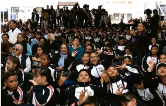 Fotografía de un grupo numeroso de estudiantes de secundaria con uniforme escolar, acompañados de docentes, reunidos en un espacio abierto durante una actividad deportiva o comunitaria escolar.