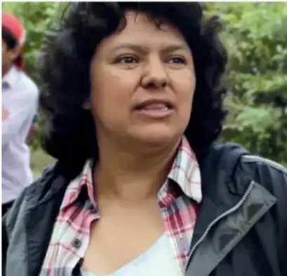 Fotografía de Berta Cáceres al aire libre, con camisa a cuadros y chamarra.