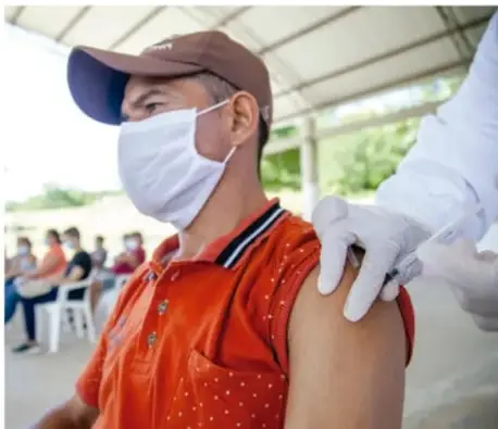 Persona recibiendo una vacuna en el brazo por personal de salud.