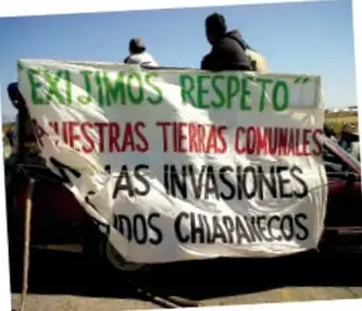 Fotografía de una manta blanca con letras rojas y verdes: 'Exigimos respeto a nuestras tierras comunales... fuera las invasiones de chapenecos'.