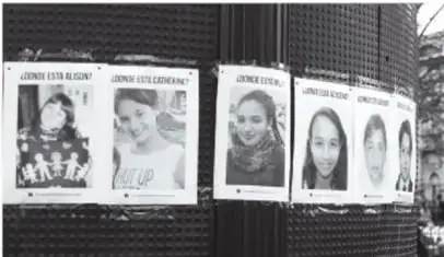 Carteles con rostros de personas desaparecidas pegados en un muro.