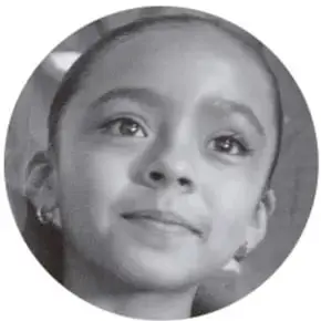 Fotografía en blanco y negro del rostro de una niña con una ligera sonrisa.
