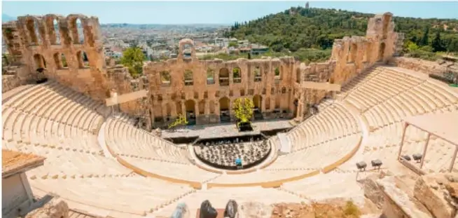 Fotografía del Teatro Romano de Mérida (España): gradas semicirculares, orchestra y una imponente fachada escénica con columnas que parece un edificio.