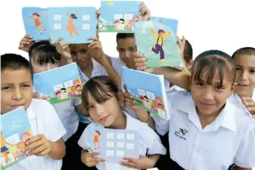 Grupo de niños de primaria mostrando carteles con dibujos de actividad física.