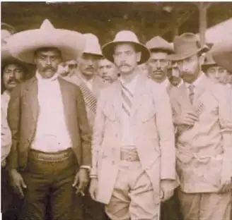 Fotografía antigua en blanco y negro de hombres armados con sombrero, identificados como villistas.