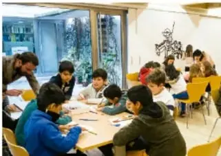 Estudiantes trabajando en equipo en un aula.