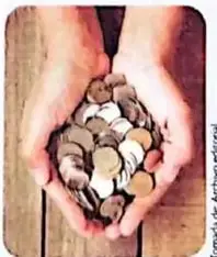 Fotografía de manos sosteniendo varias monedas.
