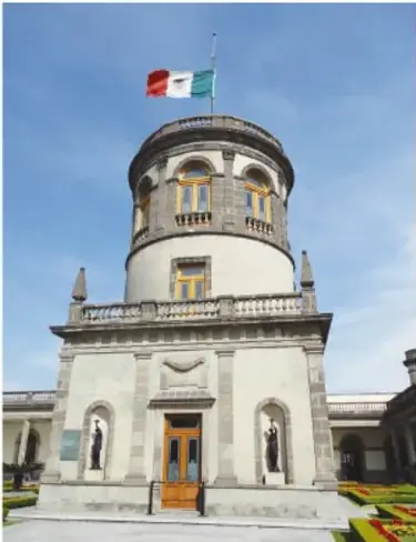 Fotografía del domo blanco y cilindro rojo del Observatorio de Tonantzintla, con escalera exterior y árboles al fondo.