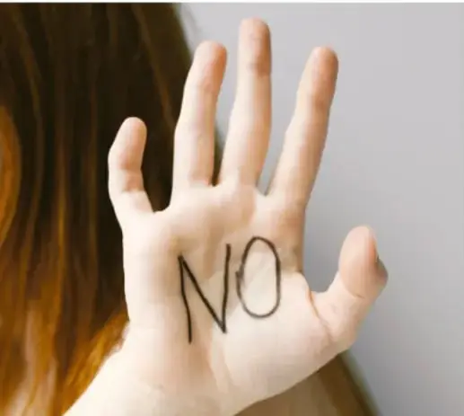 Mano abierta con la palabra "NO" escrita en la palma, símbolo de poner límites.