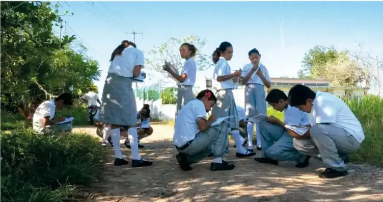 Grupo de estudiantes de secundaria con uniforme, tomado notas en un área verde al aire libre; crédito a Jesús Eduardo Arteaga Flores, Tamaulipas.