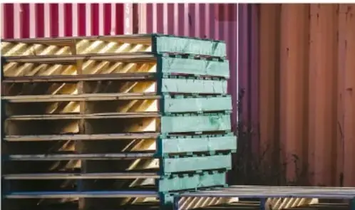 Fotografía de una pila de estructuras o estanterías metálicas/industriales apiladas, ilustrando temas de producción, residuos o entorno urbano-industrial.
